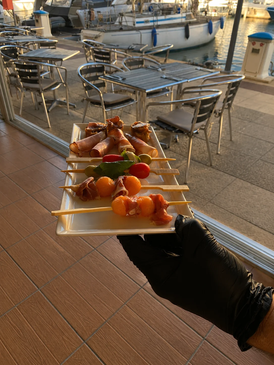 Service d'une assiette de brochettes devant le port